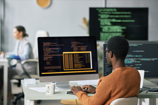 Young Black man testing programming code he wrote for new application