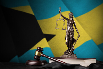 Bahamas flag with statue of lady justice, constitution and judge hammer on black drapery. Concept...