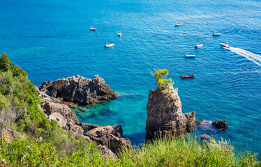 Beautiful seascape at La Grotta Bay, Corfu, sunny summer day - small boats on calm sea in distance - obrazy, fototapety, plakaty