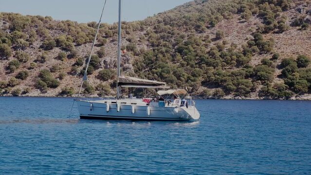 Beautiful bay with sailing boat, yacht in turquoise sea and mountains, luxury holidays or sailing regata sports.