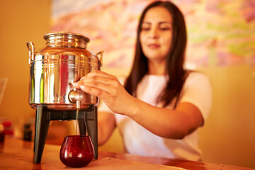 silhouette of a woman filling a glass with olive oil for the tasting of her clients