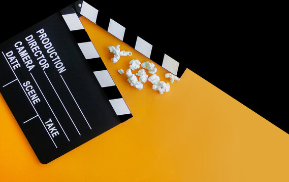 
stylish mockup with clapperboard in black and orange colors. copy space, space for text. top view. flat lay style. concept cinema party, film industry, movie premiere