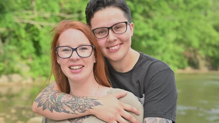 Women embracing and smiling into camera.