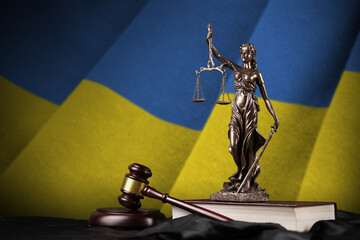 Ukraine flag with statue of lady justice, constitution and judge hammer on black drapery. Concept...