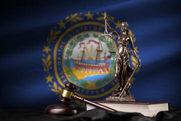 New Hampshire US state flag with statue of lady justice, constitution and judge hammer on black drapery. Concept of judgement and guilt - obrazy, fototapety, plakaty