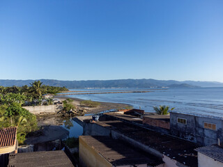 quiet beach with flowing river and small coastal town