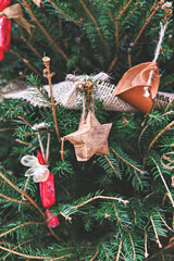 Vintage wooden star and leather toy on Christmas tree. Natural DIY ornaments for Christmas tree, zero waste Christmas, soft focus