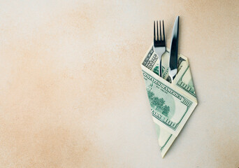cutlery knife and fork wrapped with dollar bills