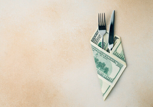 cutlery knife and fork wrapped with dollar bills