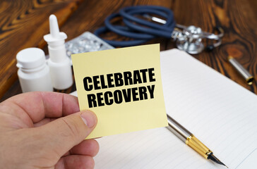 The doctor is holding a sticker with the inscription - Celebrate Recovery
