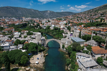 Fototapeta na wymiar Fantastic Skyline of Mostar with the Mostar Bridge, houses and minarets, during sunny day. Mostar, Old Town, Bosnia and Herzegovina, Europe
