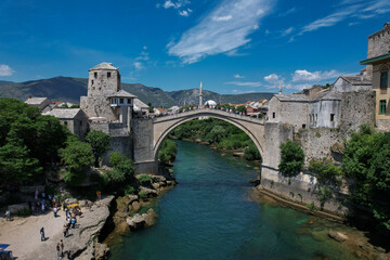 Fototapeta na wymiar Fantastic Skyline of Mostar with the Mostar Bridge, houses and minarets, during sunny day. Mostar, Old Town, Bosnia and Herzegovina, Europe