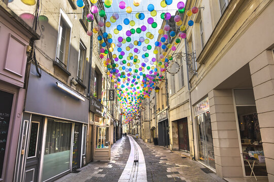 Narrow street with colorful balloons suspended over old town of Laon. Laon, Aisne, France. September 11, 2021.