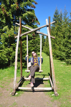 A young woman swings on a swing in the Museum-estate of I.E. Repin Zdravnevo, Vitebsk region, Belarus