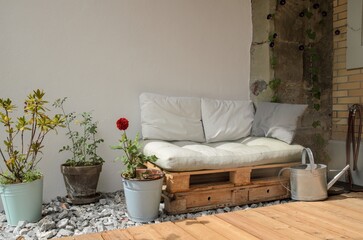 Pallet couch on terrace. Outdoor relax place with cozy pillow on wooden couch.