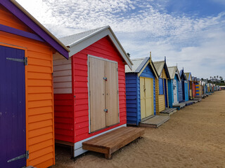colorful wooden houses on sand, beach boxes huts, shelter from sun, bathing box on coast