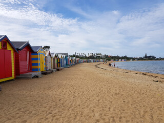 colorful wooden houses on sand, beach boxes huts, shelter from sun, bathing box on coast