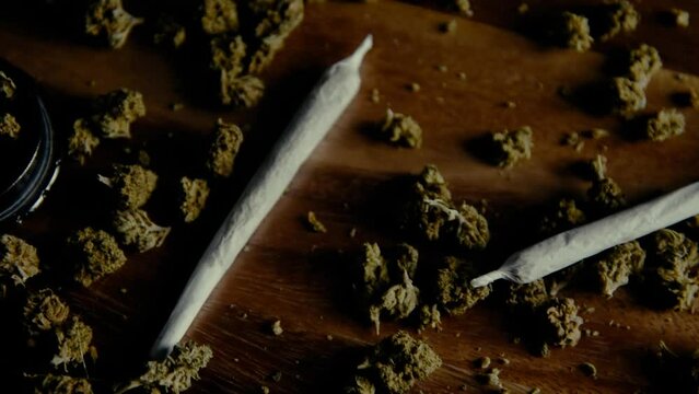 Marijuana drugs on a wooden table. Smoking pipe, grinder and cbd sativa or indica tgk buds. Paper for joints.