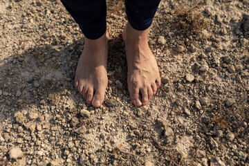 Bare feet of a man, in connection with the earth and nature, during a yoga session in the countryside