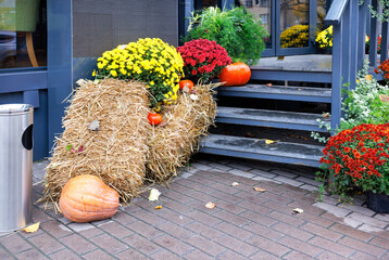 Halloween has decorated the caf?'s entrance steps with pumpkins, straw bales and fall flowers.