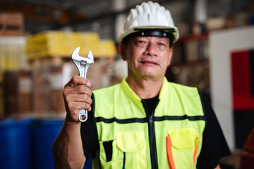 Close-up mechanic hand with his tool holding a spanner while at warehouse.