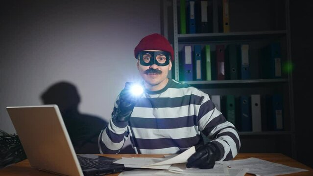 thief in mask confidential files in an office night time