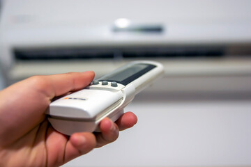 Air conditioner with remote controller Air condition control by using remote control Air conditioner inside the room with operating remote controller Air conditioner with remote controller