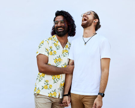 Portrait of Male LGBTQ+ couple laughing on a white background