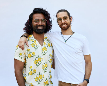 Portrait of Male LGBTQ+ couple smiling to camera on a white background