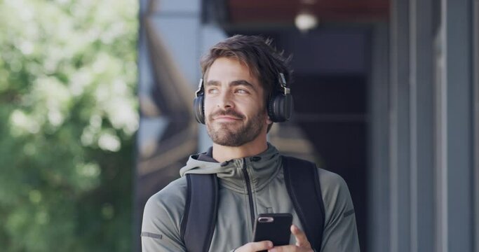 Smartphone, headphones and man outdoor in city while walking and relax. Male, phone and headset listen to podcast, streaming music and casual with trendy, edgy and stylish look to browse internet.