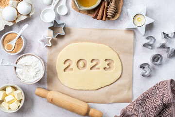 Homemade cookie dough in the form of numbers 2023. The concept of baking for New Year and Christmas.