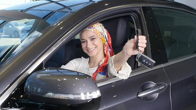 A young Muslim woman with keys from a new car