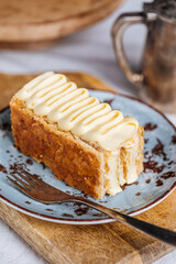 French dessert called Mille Feuille or Napoleon cake on rustic wooden board. Layered tasty cake with vanilla cream and puff pastry.