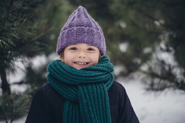 Photo of cheerful charming little child dressed coat smiling enjoying snowy weather outdoors urban forest park