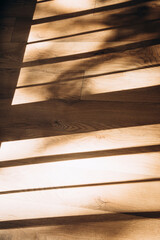 Shadows near the window from daylight in the form of stripes on the wooden floor. Abstract background for design