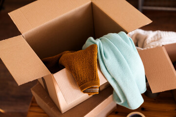 Close up of cardboard box parcel with clothes inside.