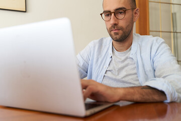 Young male with glasses using laptop