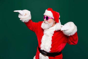 Profile side view cheerful positive carefree careless happiness aged mature Santa headwear tradition costume fooling around under music raised hands up isolated on noel red background
