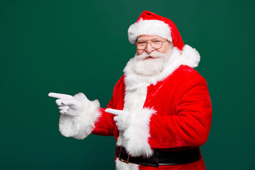 Choice choose sale discount concept. Aged Santa in costume gloves headvear with white beard point forefinger two hands aside show alternative or direction recommend isolated on vivid red background