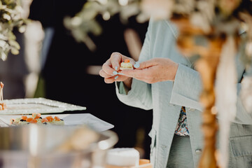 Obraz premium Femme picorant au buffet apéritif 