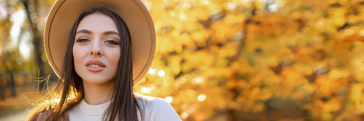 Cheerful beaut Happy smiling young woman in the park on a sunny autumn day. 