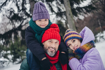 Portrait of three peaceful positive people embrace toothy smile walking snowy forest outside