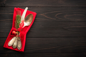 Fototapeta na wymiar Christmas food, christmas table setting with cutlery and christmas decorations on dark wooden background. Top view.