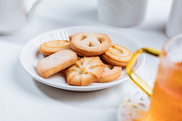 Cookies and tea in glass mug served in bright Christmas atmosphere. Bright and light scene setup.