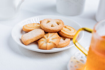 Cookies and tea in glass mug served in bright Christmas atmosphere. Bright and light scene setup.