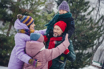 Photo of cheerful positive little child wife husband dressed coats riding shoulders having fun together outdoors urban forest park