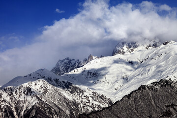Obraz premium Snow mountains in clouds in winter sun day