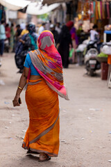Mujer hindú vestida con sari caminando por la calle