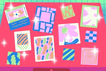 Variety of colorful drawings on paper on top of a desk with sparkles all around
