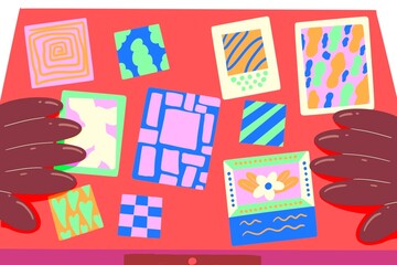Brown hands choosing the colorful drawings on a desk